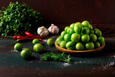Photo for Tkemali, green cherry plum, with ingredients for sauce, cilantro, mint, hot pepper, garlic, on a wooden table, close-up, rustic, food background, no people, selective focus, - Royalty Free Image