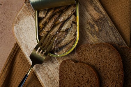 Sprats in butter, with black bread, canned smoked fish, open, close-up, top view, no people,