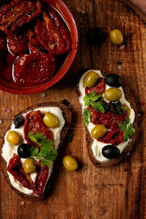 Photo for Sandwich with cream cheese, dried tomatoes, olives, breakfast, top view, - Royalty Free Image