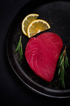 Téléchargez les photos : Filet de thon rouge frais, pour steak, cru, vue sur le dessus, sur une assiette noire, personne, - en image libre de droit
