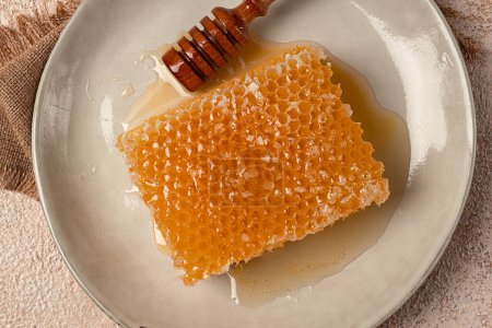 Photo for Honeycomb, with a wooden spoon-spindle, on a plate, no people, - Royalty Free Image