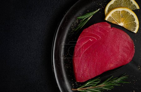 Téléchargez les photos : Filet de thon rouge frais, pour steak, cru, vue sur le dessus, sur une assiette noire, personne, - en image libre de droit