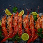 Langoustines, Australian, freshly frozen on ice, top view, lime and greens,