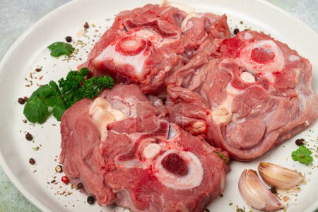 rohes Steak, Kalbshals am Knochen, frisches Fleisch, auf weißem Teller, Draufsicht, keine Menschen,