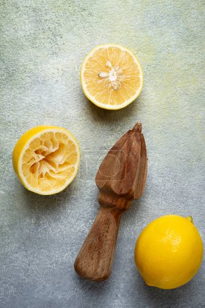 Wooden citrus reamer, manual lemon juicer, made of acacia wood, with citrus fruits on the table, top view,