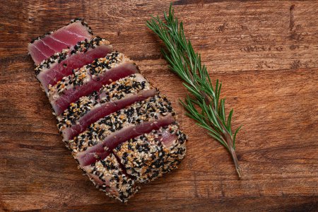 Filet aus rotem Thunfischfleisch, in Sesam gebraten, hausgemacht, Nahaufnahme, ohne Menschen, auf Holzgrund,