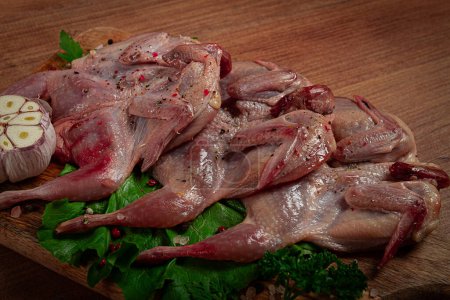 Photo for Raw quail meat, on a cutting board, with spices and herbs, top view, - Royalty Free Image