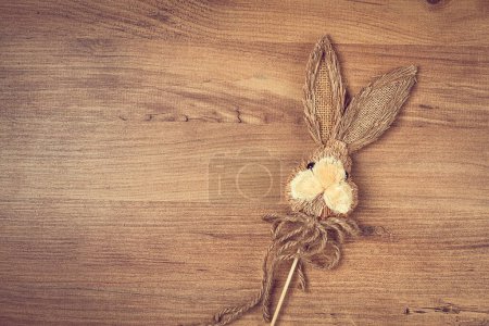 Conejo de Pascua hecho de paja, sobre un fondo de madera, vista superior, sin personas,