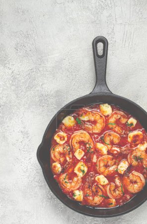 Greek saganaki, in an iron pan, saganaki with shrimp, shrimp in tomato sauce, with pepper and feta cheese, homemade, no people,