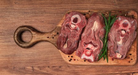 raw steak, calf's neck on the bone, fresh meat, on the cutting board, top view, no people,
