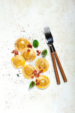 Photo for Fresh ravioli, with butter, spices and herbs, fried bacon, on the table, top view, light background, no people, - Royalty Free Image