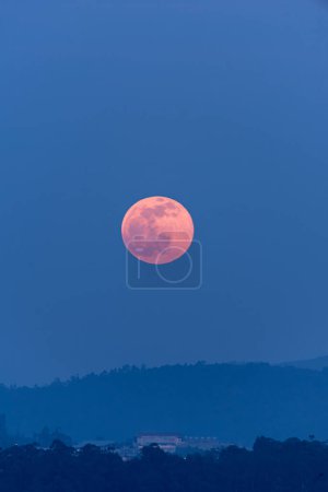 Téléchargez les photos : Landscape of pink moon in the moonrise from behind montains - en image libre de droit