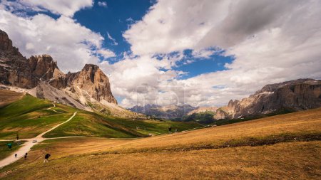 Foto de Hikers in mountains, beautiful scenic landscape of Alps, Passo San Pellegrino, North Italy - Imagen libre de derechos