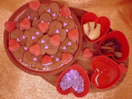 Vegetarische Kekse verschiedener Herzsorten, die mit Tauchgeräten hergestellt werden. Dekoriert mit natürlichen Säften, die mit Agar-Agar verdickt sind. Goldener Hintergrund.