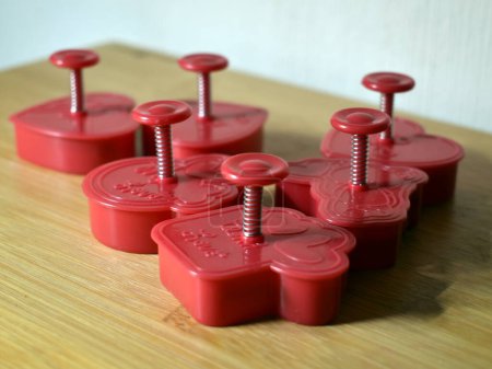 Red plungers with a spring for creating heart-shaped cookies