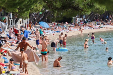 Photo for Makarska, Croatia, 02.06.2023.Tourists enjoy their annual vacation in Croatia, on the beach by the sea - Royalty Free Image
