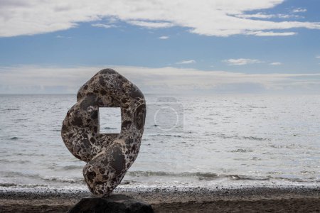 Photo for Unusual shape of a rock with a hole inside, to frame the photos of the Atlantic ocean. Beach in Tarajalejo, Fuerteventura, Canary Islands, Spain. - Royalty Free Image