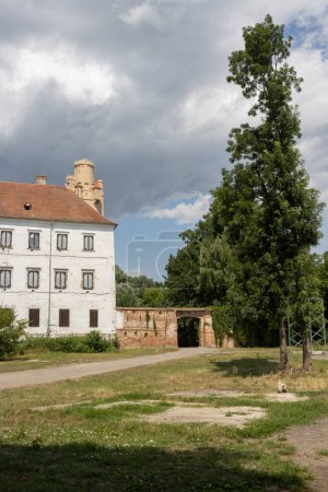 Ruina de una mansión, que se supone que debe ser renovada. Típica torre. Edificio en un parque. Nublado cielo lluvioso. Breclav, Moravia, República Checa.