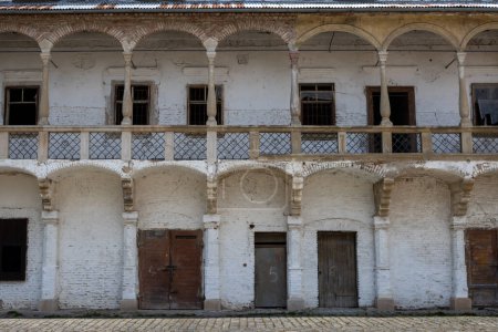 Patio de la mansión. Paredes pintadas de blanco. Varias puertas y arcada en el primer piso. Ruina de una mansión histórica, Breclav, Moravia, República Checa.