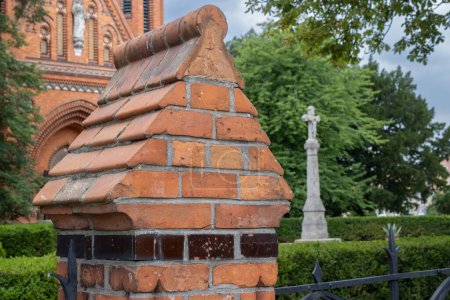 Detail of a fence, built in the same style as the building of a neo-gothic church of Visitation of Virgin Mary, made of orange bricks. Postorna, Breclav, Moravia, Czech republic.