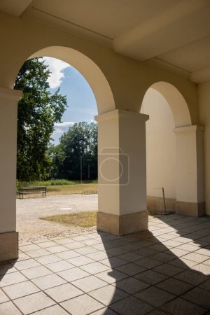 Arcades of the Chateau, with a view to the park, surrounding the building. Fresh trees and blue sky with white clouds. Pohansko, Breclav, Moravia, Czech republic.