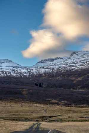Foto de Inicio del atardecer durante un día con cielo azul y algunas nubes. Majestuosas montañas con poca nieve en otoño. Zona de Westfjords, Isafjordur, Islandia. - Imagen libre de derechos