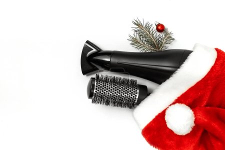 Photo for Christmas composition. Hairdressing tools and a spruce branch on a white background, hair dryer, comb. Template for a postcard or information about a hair salon. Flat lay, copy space - Royalty Free Image