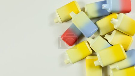 Téléchargez les photos : Un ensemble de cigarettes électroniques jetables multicolores sur un fond clair gros plan. Le concept de tabagisme moderne, vapotage et nicotine - en image libre de droit