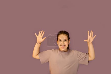 Photo for A cheerful attractive teenage girl poses against a purple wall. Summer concept. The style of the Zoomer generation. The concept of social networks - Royalty Free Image