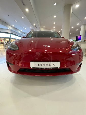 Téléchargez les photos : Alicante, Espagne - 5 octobre 2023. Nouveau véhicule électrique Tesla Modèle Y exposé dans un centre commercial. Voiture électrique rouge dans le centre commercial. Photo verticale - en image libre de droit