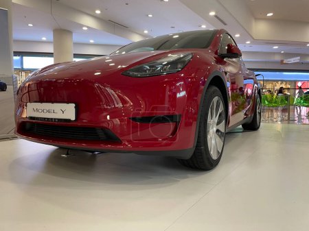 Téléchargez les photos : Alicante, Espagne - 5 octobre 2023. Nouveau véhicule électrique Tesla Modèle Y exposé dans un centre commercial. Voiture électrique rouge dans le centre commercial. Photo grand angle horizontale - en image libre de droit