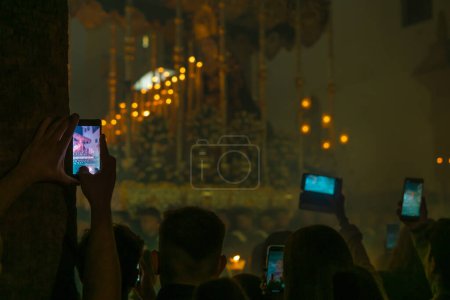 Photo for April 8th 2023 - Dona Mencia, Cordoba, Spain. Mobile phone held by people croud recording Virgin Mary in the spanish celebration of Holy Week. Easter in Spain, devote - Royalty Free Image