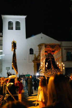 Photo for April 8th 2023 - Dona Mencia, Cordoba, Spain. Procession of the Virgen de la Soledad, Spanish Celebration of Holy Week. Entering the church. Vertical shot, low-angle, warm light - Royalty Free Image