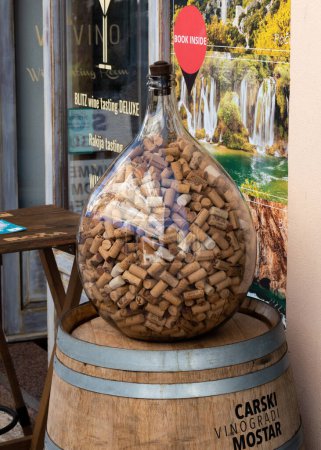 Photo for Big glass bottle full of corks, wine corks - Royalty Free Image