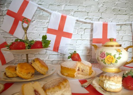 Feier St. Georges Tag Nachmittagstee Weinlese traditionelle Scones Erdbeeren und Sahne Viktoria Biskuitkuchen England Flagge Fahnenmeer 