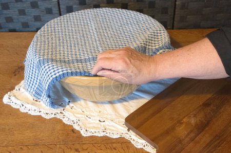 traditional  old fashion  micxing  bowl  loving  bread  covered with a  blue and  white  checked cloth
