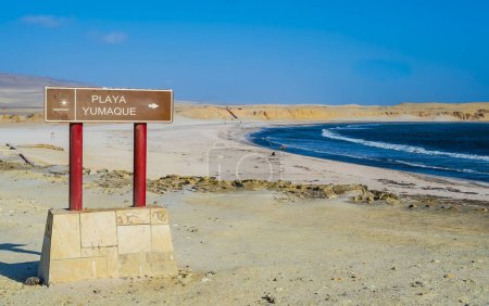 Foto de Vista panorámica de la playa de Yumaque con letrero turístico en primer plano, Reserva Nacional Paracas, Perú - Imagen libre de derechos