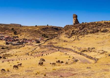 Foto de Vista panorámica del sitio arqueológico de Sillustani con su chullpa más alta (torre funeraria) y el pueblo turístico en el fondo, región de Puno, Perú - Imagen libre de derechos