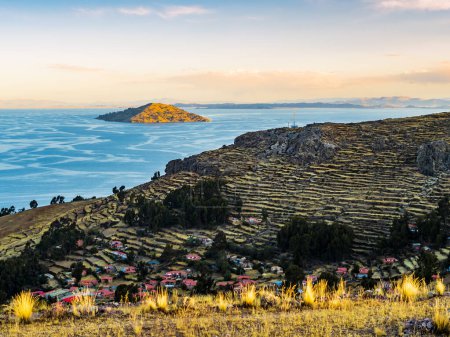 Impresionante paisaje en la isla Amantani al atardecer con campos escalonados, Lago Titicaca, región de Puno, Perú