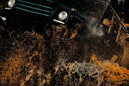 Photo for Tires in preparation for race. Jeep crashed into a puddle and picked up a spray of dirt. Mud and water splash in off-road racing - Royalty Free Image