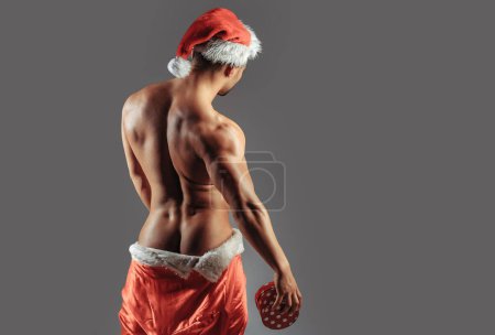 Christmas sexy man with gift. New year strip and gifts for adults. Muscle man torso with sexy buttocks butt. Santa with muscular body back