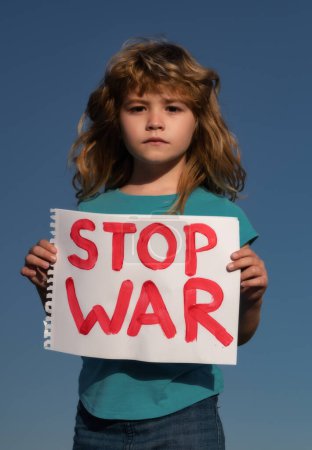 Foto de Protesta contra la guerra. Retrato Niño rubio llama a detener la guerra, levanta pancarta con la inscripción detener la guerra. Apoyo estatal en la guerra. Europa unida contra Rusia - Imagen libre de derechos