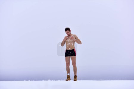 Foto de Procedimientos de templado de invierno. Hombre desnudo en la nieve. Un tipo en las lluvias de nieve por el endurecimiento del cuerpo. Invierno estilo de vida saludable - Imagen libre de derechos