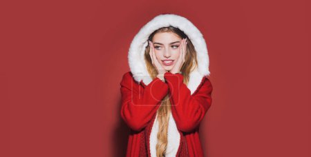 Foto de Retrato de una hermosa joven que celebra las vacaciones de Navidad de invierno aislado sobre fondo rojo. Jovencita hermosa. Feliz año nuevo - Imagen libre de derechos