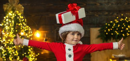 Téléchargez les photos : Joyeux enfant avec boîte cadeau de Noël. Joyeux Noël et Joyeuses Fêtes - en image libre de droit