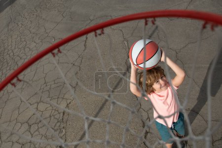 Foto de Niño jugando al baloncesto con baloncesto. Vista de la pelota voladora a la cesta desde la parte superior, niño jugar baloncesto - Imagen libre de derechos