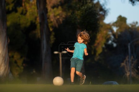 Photo for Little kid boy playing football in the field with soccer ball. Concept of children sport. Young sporty kids - Royalty Free Image