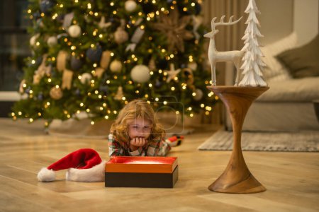 Téléchargez les photos : Enfant près de l'arbre de Noël à la maison - en image libre de droit