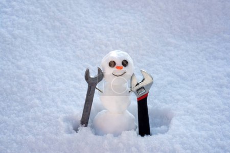 Foto de Construcción y reparación. Snowman constructor con herramientas de reparación. Felices fiestas y celebraciones - Imagen libre de derechos