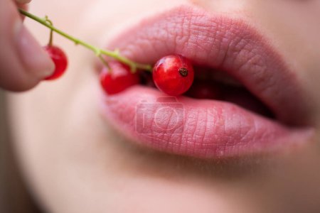 Foto de Grosella en la boca. Grosella en los labios, grosella roja. Verano sexy frutas - Imagen libre de derechos